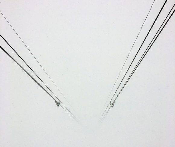 Le funi della funivia si perdono nel nulla, ma sul ghiacciaio, neve da favola