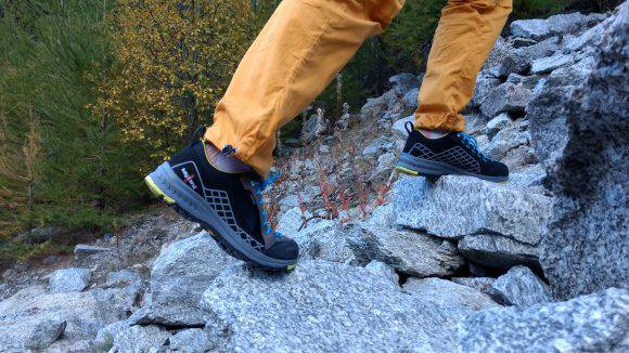 Alice testa le scarpe su terreno roccioso.