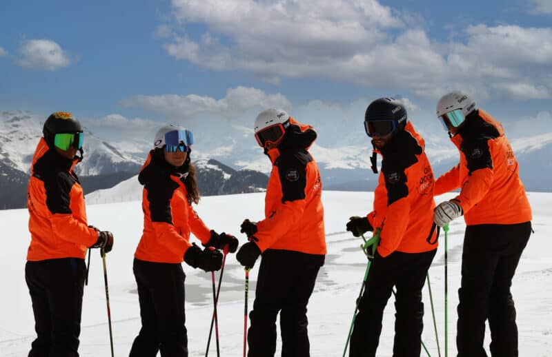 Sciatori in pista con caschi e protezioni, sicurezza in pista