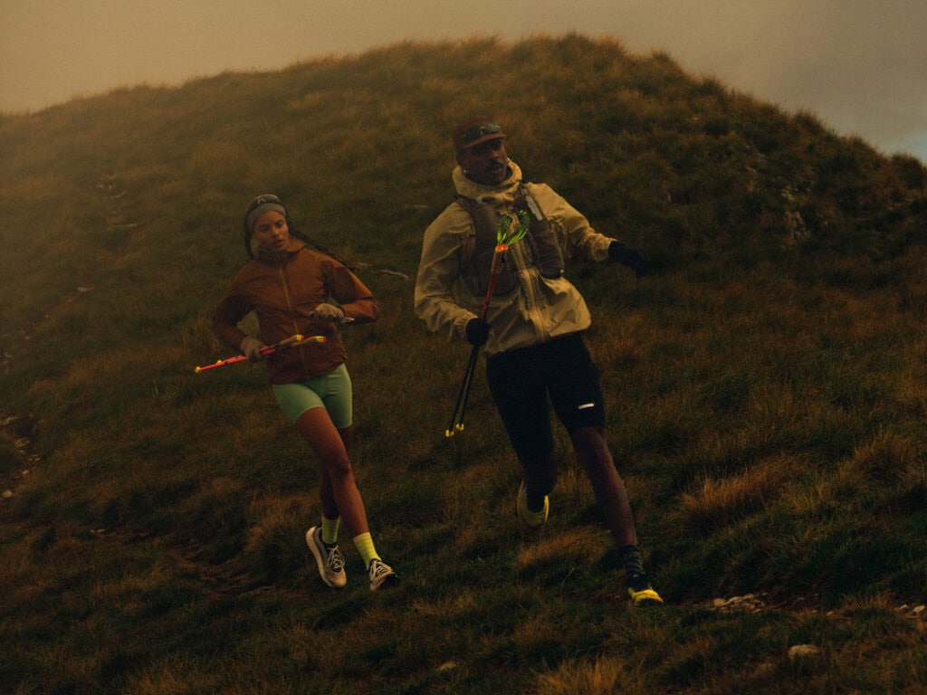 Trail runners running on alpine trail with poles KEEN outdoor lifestyle
